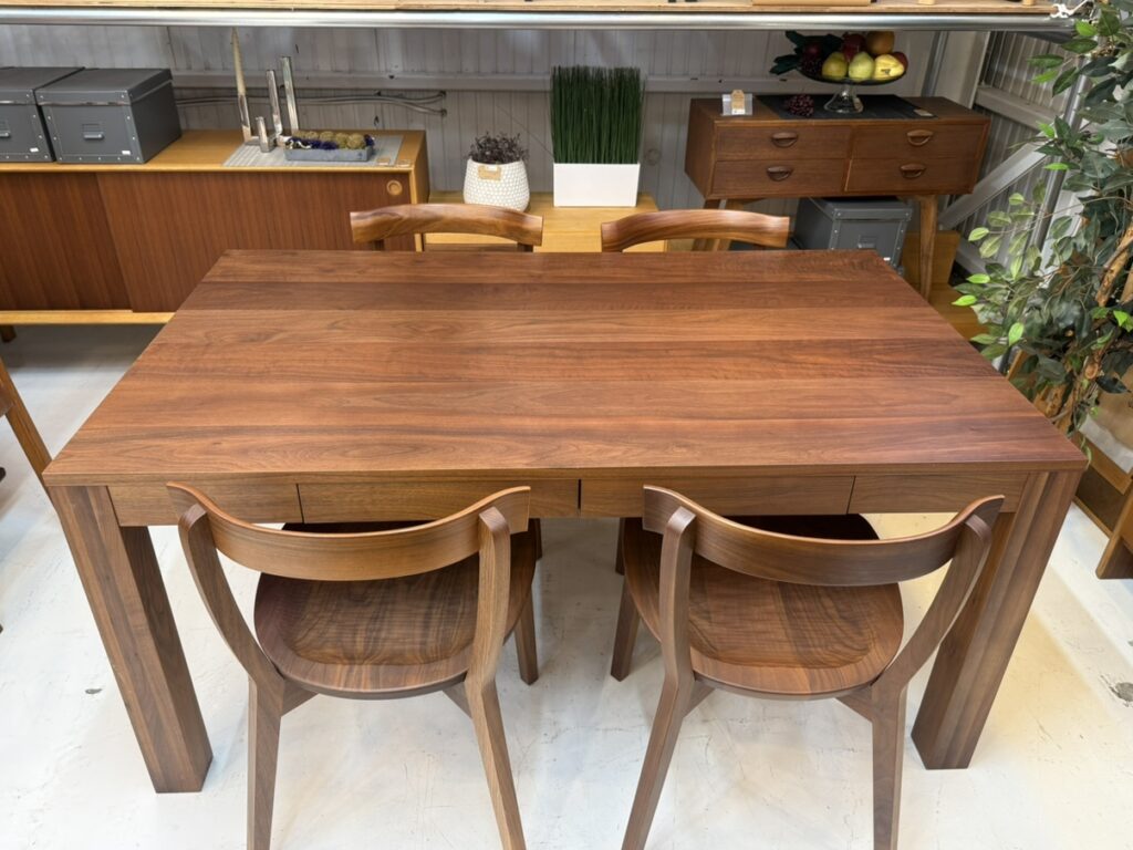 EARLY TIMES α（アーリータイムスアルファ）ウォルナットダイニング150cmダイニングチェア5点セット ダイニング用
直線と緩やかな曲線をバランスよく組み合わせたミニマルデザイン。ウォルナット材の美しい木目を引き立てるフラットな天板と細身の脚部が、空間に軽やかな抜け感を演出。旭川家具らしい精緻な造形で、インテリアに自然と溶け込む上質な佇まい。