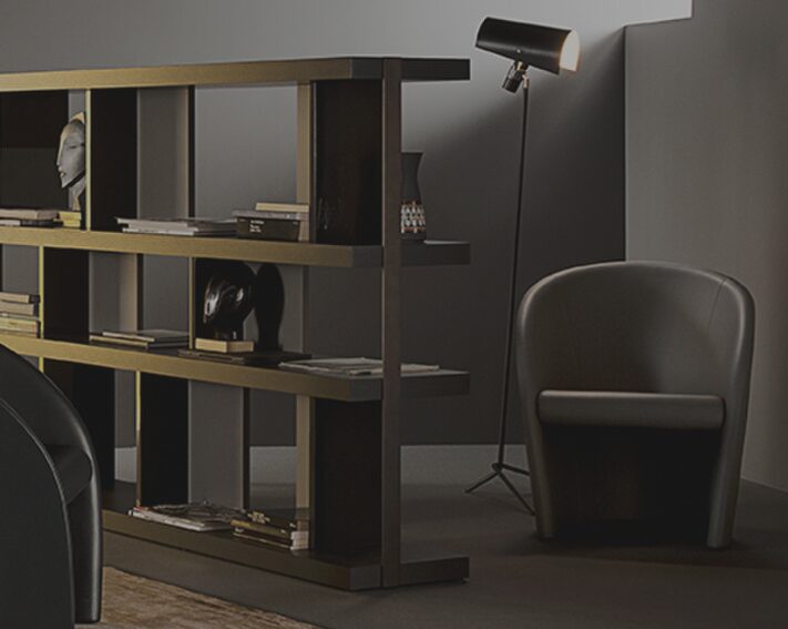 Poltrona Frau（ポルトローナ・フラウ） Intervista（インターヴィスタ）ラウンジチェア　公式サイト掲載画像　包み込む曲線アームと低重心構造が際立つスタジオ撮影写真、レザー張りの滑らかな質感とミニマルな造形が分かるプロダクトビジュアル
