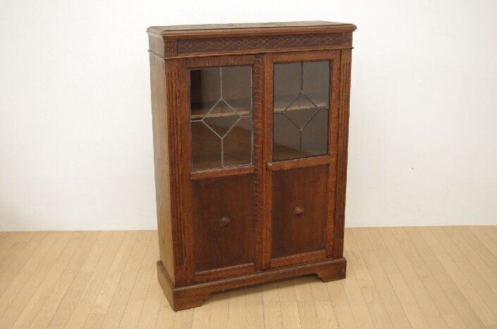 GERMAN ANTIQUE（ジャーマンアンティーク）ガラスキャビネット 収納家具 オーク材の重厚な木目とD.R.G.M刻印の金具、天板跳ね上げ式で天面収納を備えたヴィンテージデザイン
