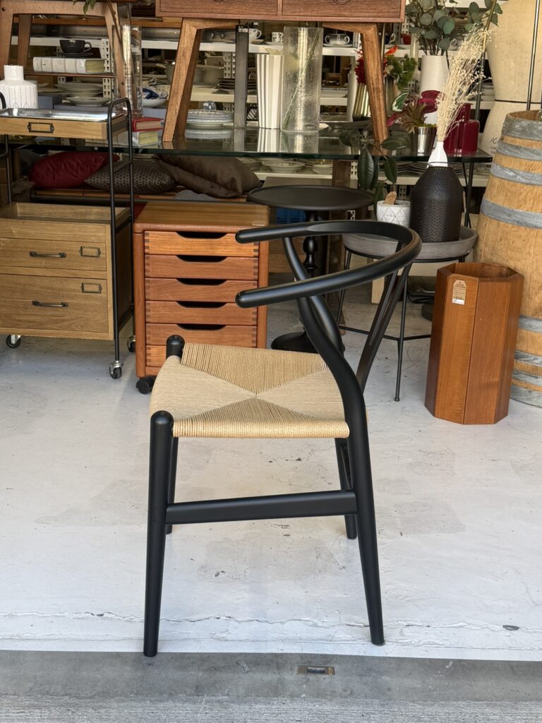 **Carl Hansen & Søn（カールハンセン&サン） CH24 Yチェア ダイニングチェア。** Soft Black（マットブラック）の落ち着いた質感が、洗練された印象を演出。木の温もりを残したビーチ材の美しいフォルムと調和し、空間を引き締める一脚です。
