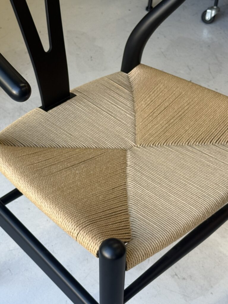 **Carl Hansen & Søn（カールハンセン&サン） CH24 Yチェア ダイニングチェア。** 熟練の職人が手作業で編み上げたペーパーコード座面は、しなやかな弾力と優れた通気性が特徴。使うほどに風合いが深まり、快適な座り心地を長く楽しめます。
