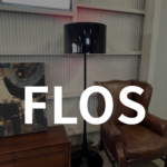 FLOS（フロス）SPUN LIGHT F フロアランプ。アルミニウム製の光沢ブラックの円筒形シェードとホワイト内面が、柔らかな光を広げるモダンな照明。