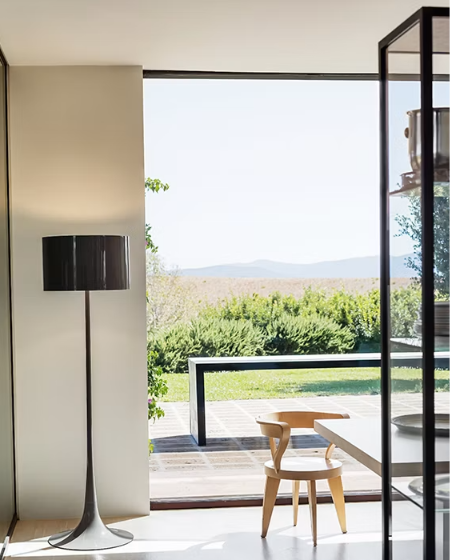 FLOS(フロス)SPUN LIGHT F フロアランプ。インテリアコーディネート案。アルミニウム製の光沢ブラックの円筒形シェードとホワイト内面が、柔らかな光を広げるモダンな照明。
