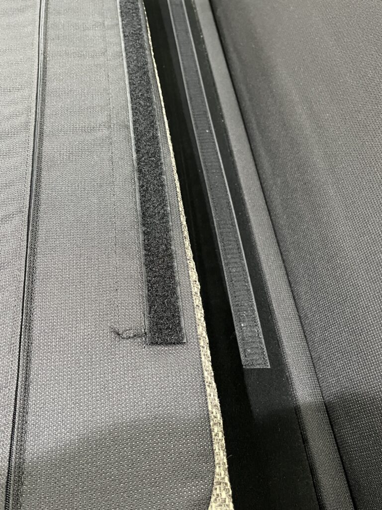 Karimoku（カリモク）WU45モデルの2人掛けロングソファ。背クッションを外した状態と取り付け部分の境界を撮影し、クッションの着脱構造と杢調ファブリックの質感を確認できるディテール。